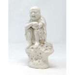 A Chinese blanc de chine figure of seated man watched by a frog, (some hairline cracking) height