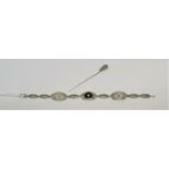 An Art Deco white metal filigree oval link bracelet stamped '14K' tests as 10 / 12 carats, set