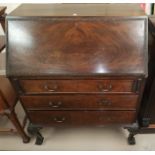 A mahogany reproduction Queen Anne style bureau with three drawers, leather insert, on ball and claw