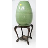 A Chinese celadon crackle glaze ovoid shaped stoneware vase on tall hardwood stand. Vase height 28cm