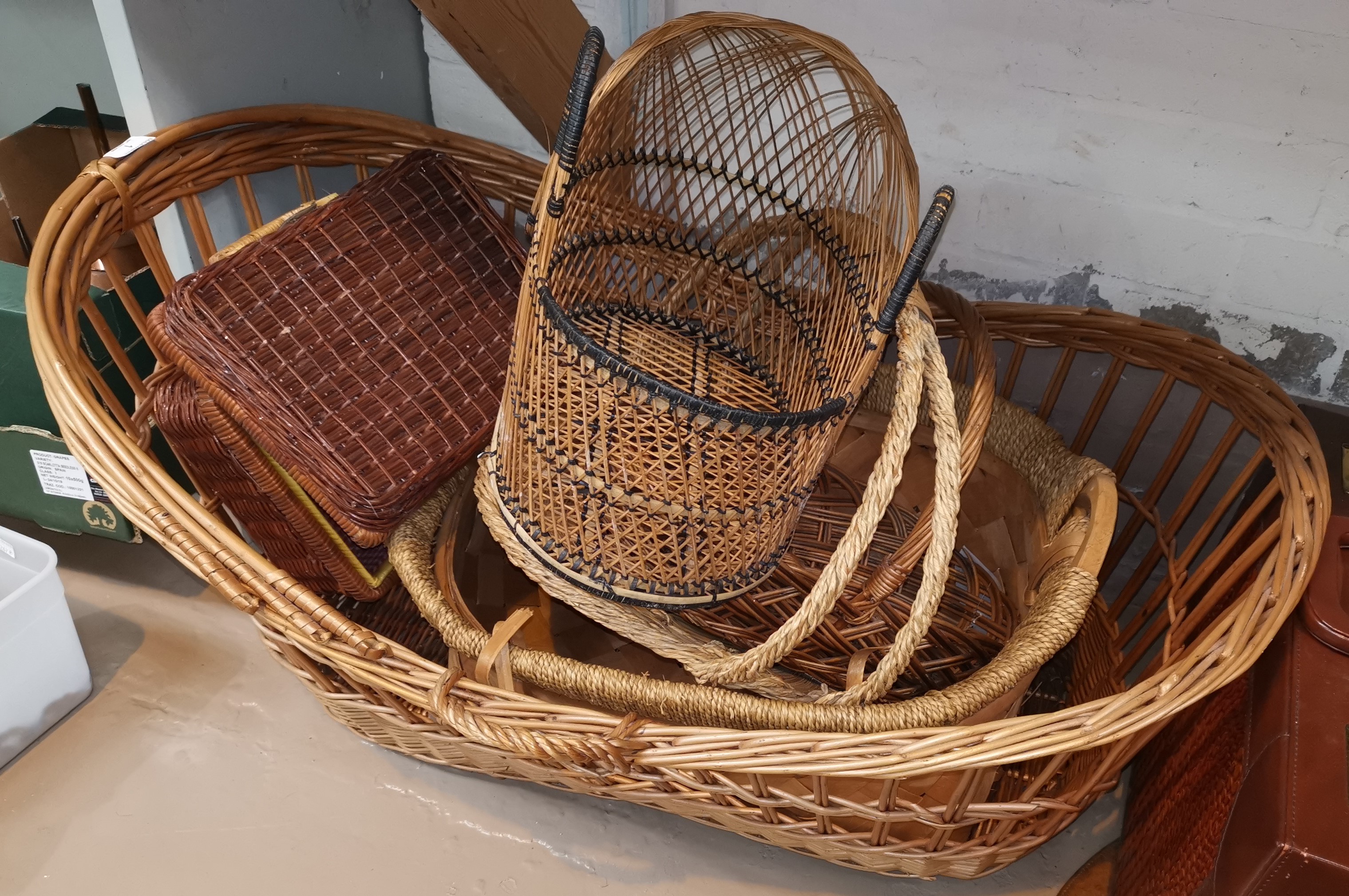 A wicker crib and other basketware; a Lloyd Loom linen box