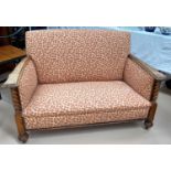 A small 1930's oak barley twist leg 2 seater settee in patterned fabric