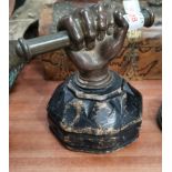 A 19th century doorstop in the form of a clenched fist, bronze on wood, height 15 cm