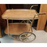 A mahogany reproduction cocktail cabinet and a 1950's gilt drinks trolley