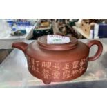 A Chinese Yixing terracotta coloured stoneware teapot of squat circular form, square impressed seal