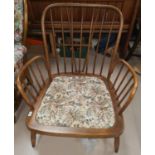An Ercol stick back armchair with floral upholstery