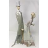 A Lladro group: man in top hat and lady with dog, height 61 cm (no parasol)