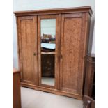 A Victorian pitch pine triple wardrobe wit central mirror and panelled side doors