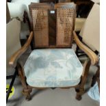 A 1930's stained walnut armchair with cane back and low seat
