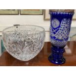 A large heavy cut glass bowl and a blue overlaid large trumpet shaped vase