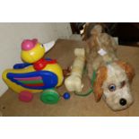 A vintage battery operated toy 'dog and bone'; a pull-along duck toy; a child's potty/highchair (