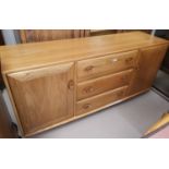 An Ercol Windsor style sideboard of 2 cupboards and 3 drawers