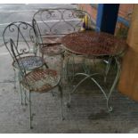 A wrought metal patio set comprising table, chairs and settee