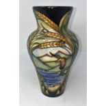 A modern Moorcroft vase of inverted baluster form, decorated with ears of wheat and reserve panels