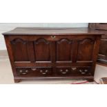 An 18th century country made oak mule chest with hinged top, 4 arched fielded panels to the front