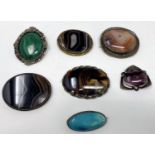 A selection of various polished hardstone brooches