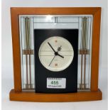 A modern mantel clock by Bulova in wood and glass frame