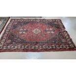 A Persian hand knotted rug with red ground