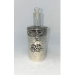 An Edwardian hall marked silver cylindrical scent bottle enbosed with cherubs with glass liner and