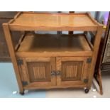 A light oak 'Agincourt' tea trolley with double shelves over double linenfold panel doors