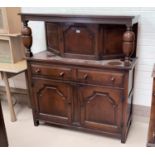 A reproduction oak court cupboard with single cupboard over 2 drawers and 2 cupboards