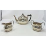 A Georgian style rounded rectangular three piece hall marked silver tea set with ribbed body and bun