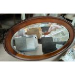 A 1920's oval wall mirror in mahogany frame