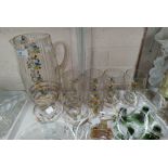 A 1950's squash set with painted gilt and floral decoration; a selection of drinking glasses