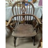 A 19th century elm Windsor armchair with low back and pierced splat, on turned legs