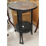 A German Arts & Crafts ebonised table with copper circular top, undershelf height 73 cm