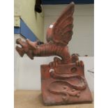 A roof apex/garden ornament in the form of a terracotta coloured dragon, height 57 cm (chip to