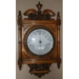 An Edwardian aneroid barometer in carved golden oak frame