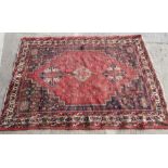 A hand woven Afghan carpet rust ground with geometric design 220cm x 136cm
