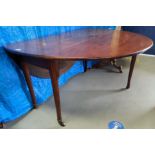 A Georgian mahogany dining table with oval drop leaf top, on turned legs and castors, 140 cm