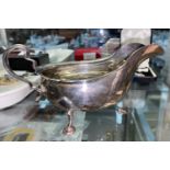 A Georgian style hall marked silver sauce boat with wavy rim and four hoof feet Sheffield 1919 4.7oz