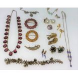 An amethyst colour necklace, brooches, earrings etc