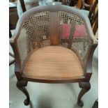 An early 20th century bergère armchair in stained walnut, on cabriole legs