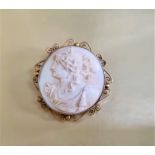 A Victorian ivory circular brooch carved in relief with female bust profile, in yellow metal