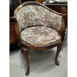 An Edwardian tub shaped armchair with acanthus carved frame and cabriole legs, up;holstered in