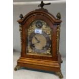 A Georgian style bracket clock in oak case with ornate brass mounts, brass dial and ting tang