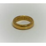 A yellow metal 'D' wedding ring, tests as 20+ cart