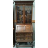 A 1930's oak bureau book case with double glazed cupboard above and two drawers bellow.