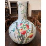 A very large Chinese porcelain bottle vase decorated in polychrome with peaches on branches, with