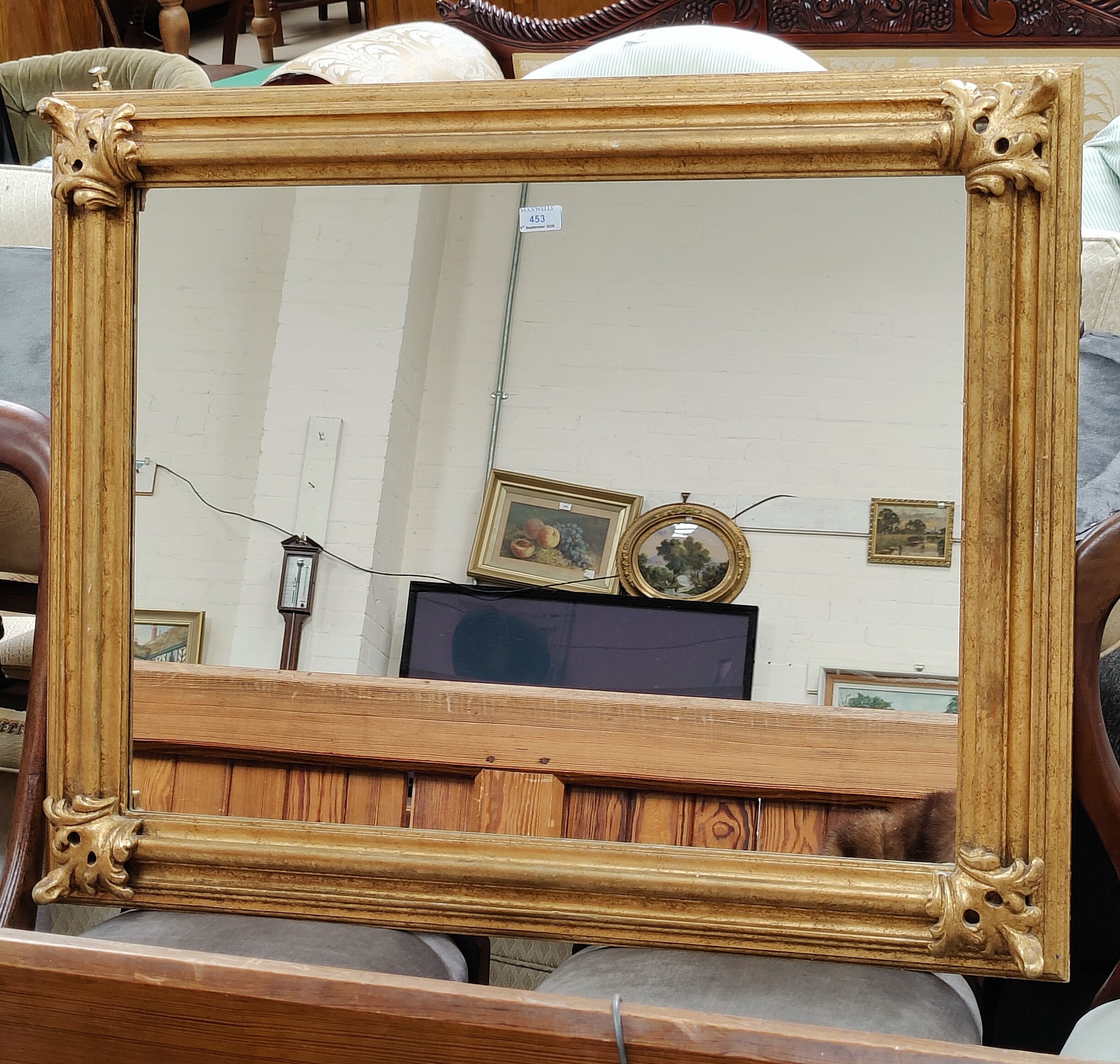 A gilt framed rectangular wall mirror with accanthus corner mounts 97cm x 79 cm A pair of table