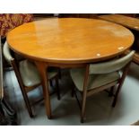A mid 20th century circular extending dining table by Macintosh and four teak tapering seat chairs