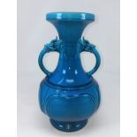 A Chinese turquoise glazed vase with double handles opening from the mouths of mythological