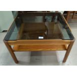 A mid 20th century teak coffee table with smoky glass top by Nathan