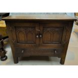 A reproduction oak dwarf side cabinet with twin doors and base drawer