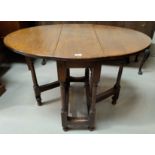 An oak occasional/dining table with oval drop leaf top