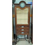 An Edwardian mahogany narrow display cabinet with painted roundel, glazed door over 3 drawers